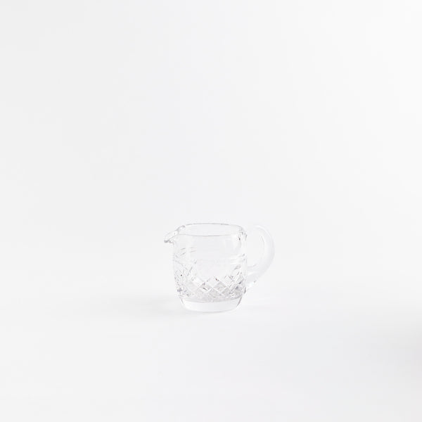 Clear glass jug with etched design.