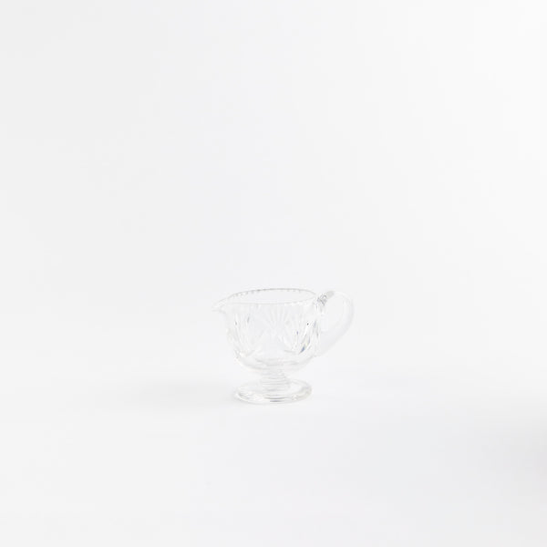 Clear glass jug with etched design.