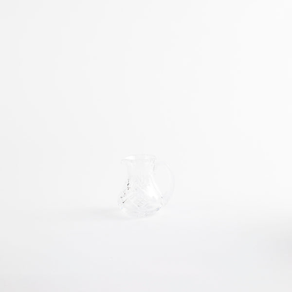 Clear glass jug with etched design.