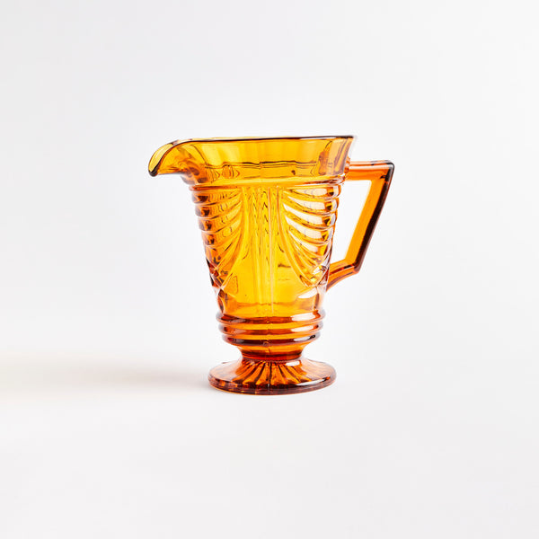 Orange jug with embossed design.