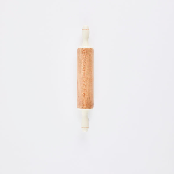 Wood rolling pin with white handles.