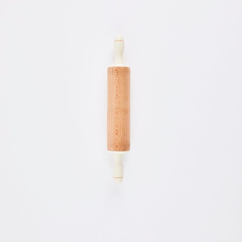 Wood rolling pin with white handles.