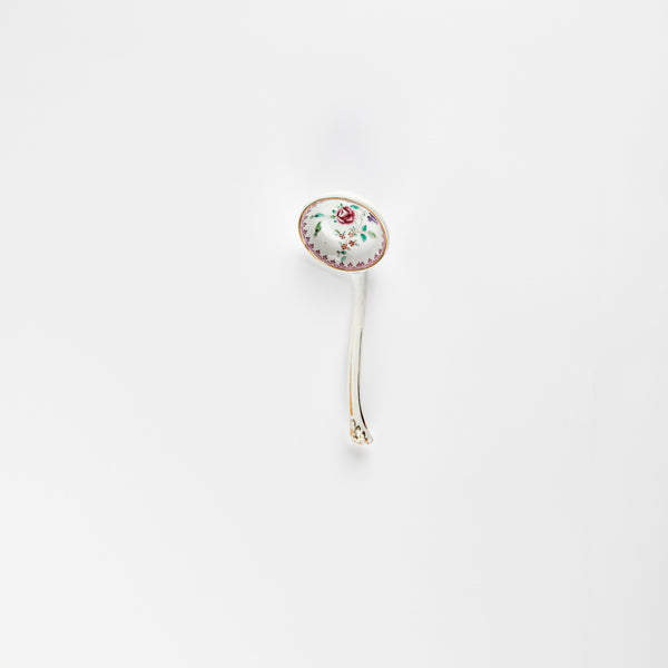 White ceramic ladle with pink floral detail.