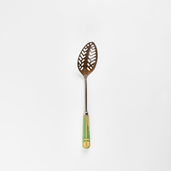 Silver slotted spoon with green wooden handle.