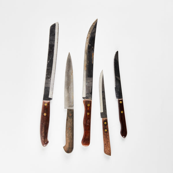 Five silver knives with wooden handles.