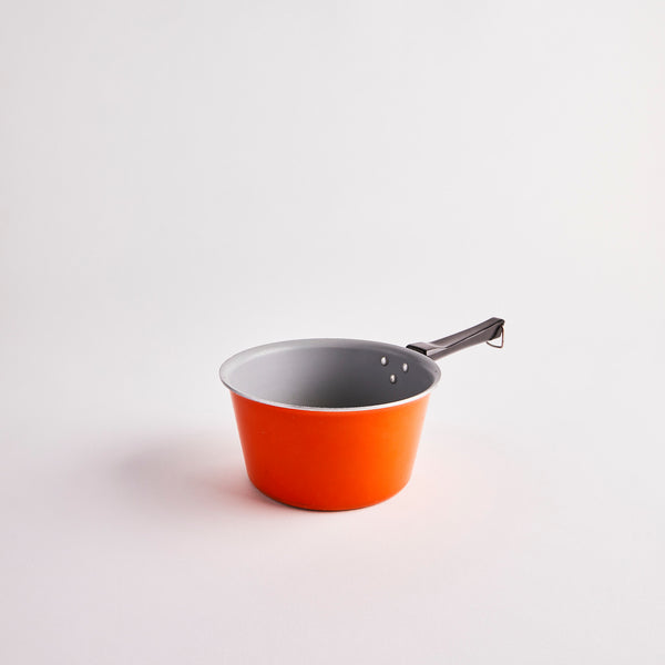 Orange pot with black handle.