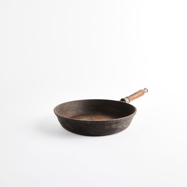 Cast iron pan with wooden handle.