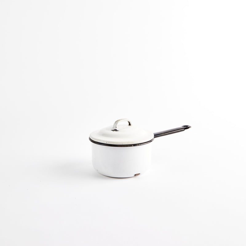 White pot with black handle and lid.