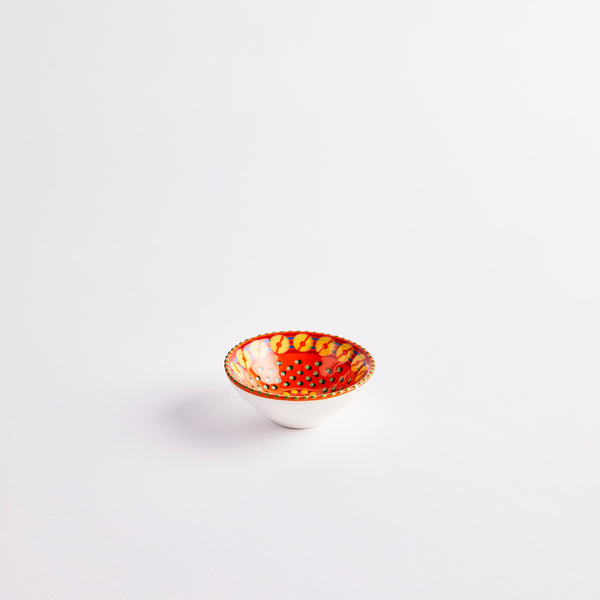 Glazed orange ceramic pinch pot.