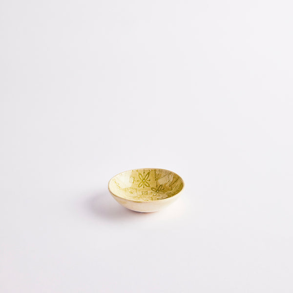 Yellow ceramic pinch pot with embossed design.