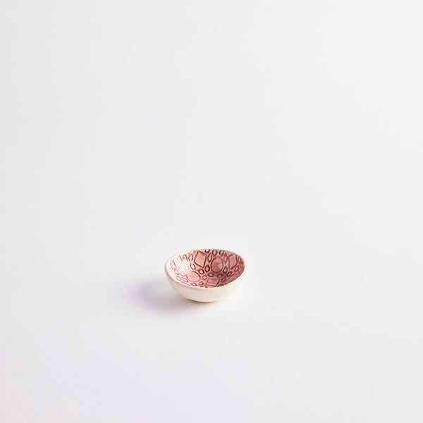 Pink ceramic pinch pot with embossed design.