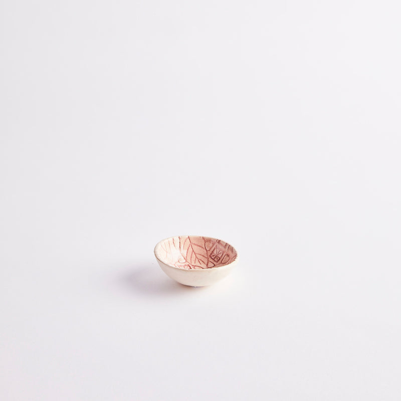 Pink ceramic pinch pot with embossed design.