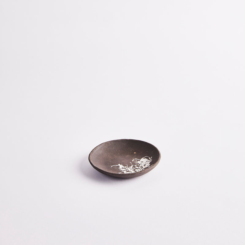 Black pinch pot with white leaf design.