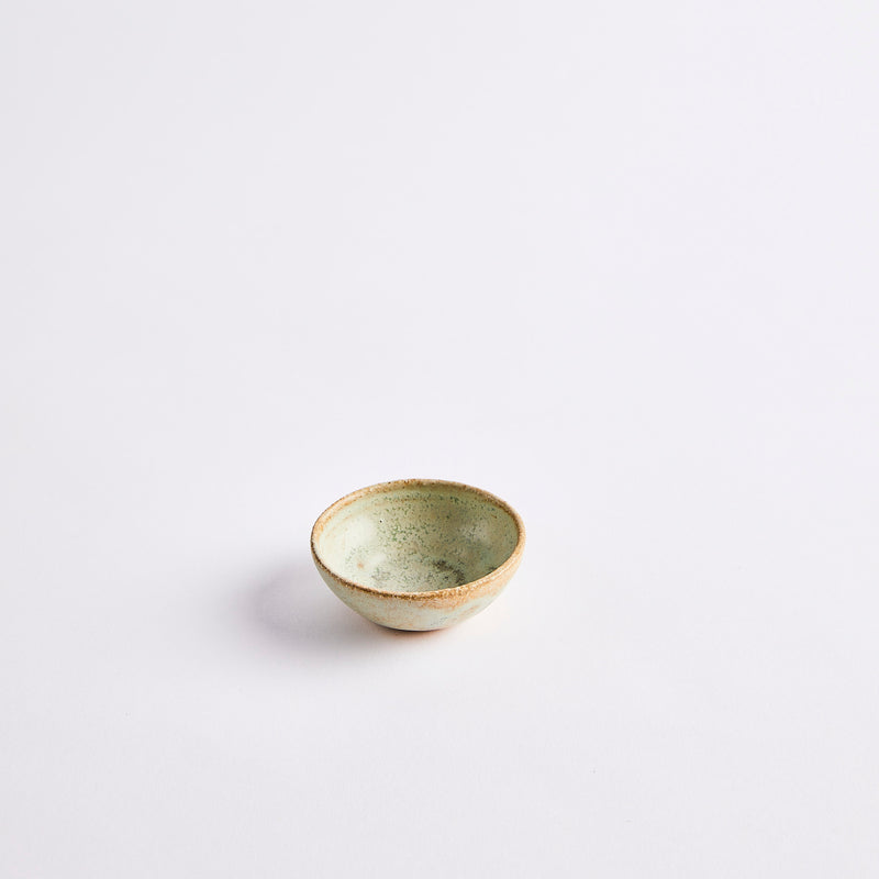 Green pinch pot with brown rim.