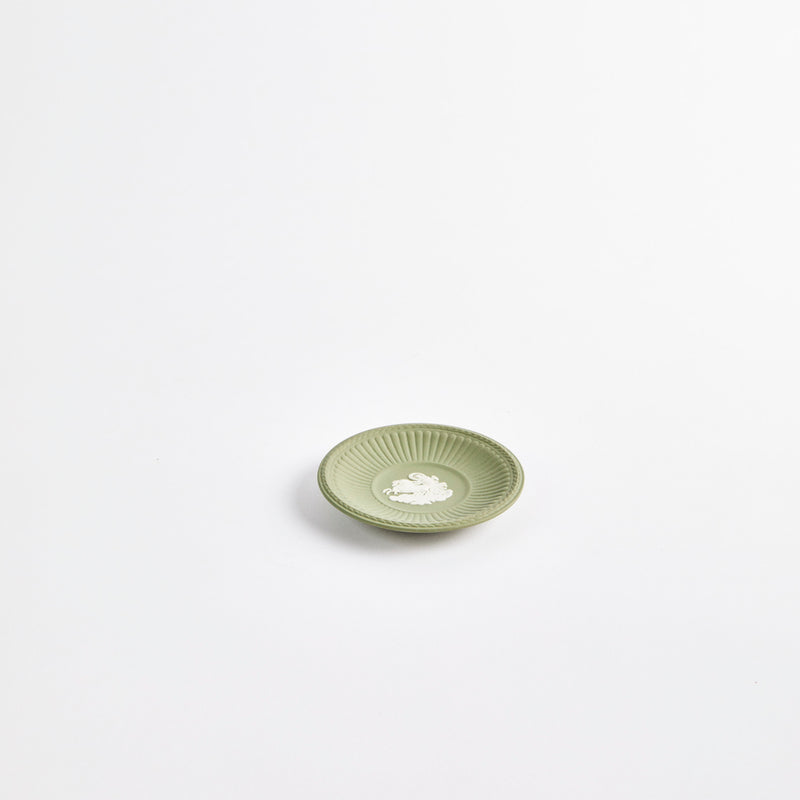 Mini green plate with white embossed design in the center.