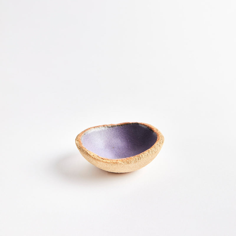 Brown ceramic pinch pot with purple interior.