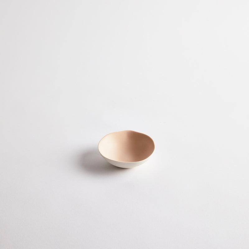 White mini ceramic dish with pink interior.