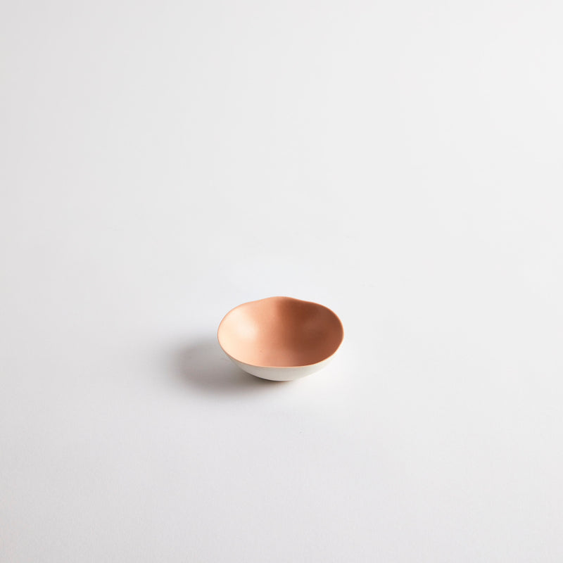 White mini ceramic dish with pink interior.