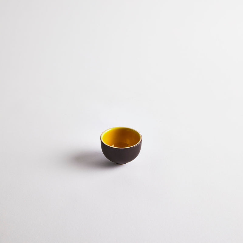 Brown pinch pot with yellow interior.