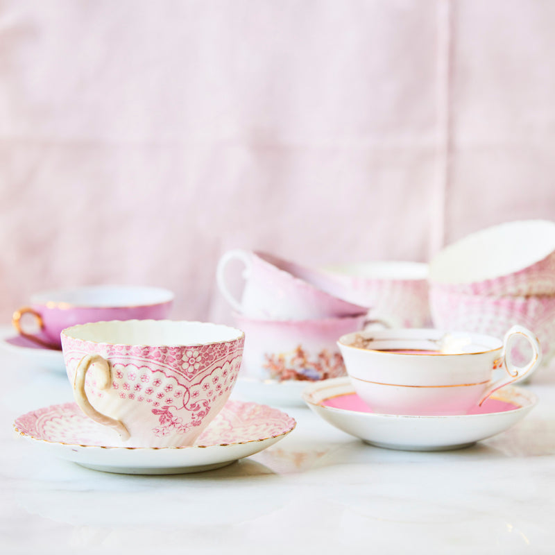 Pink and white tea cups with saucers.
