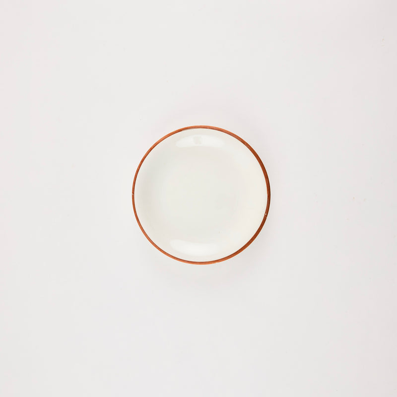 Cream plate with terracotta rim.