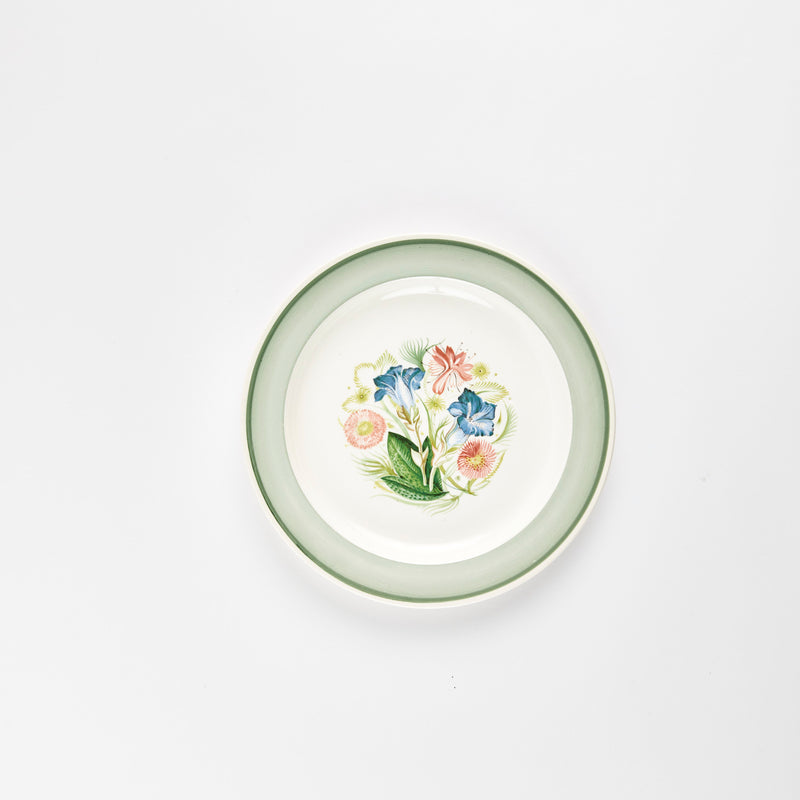 White plate with green rim and multicolour flower design.