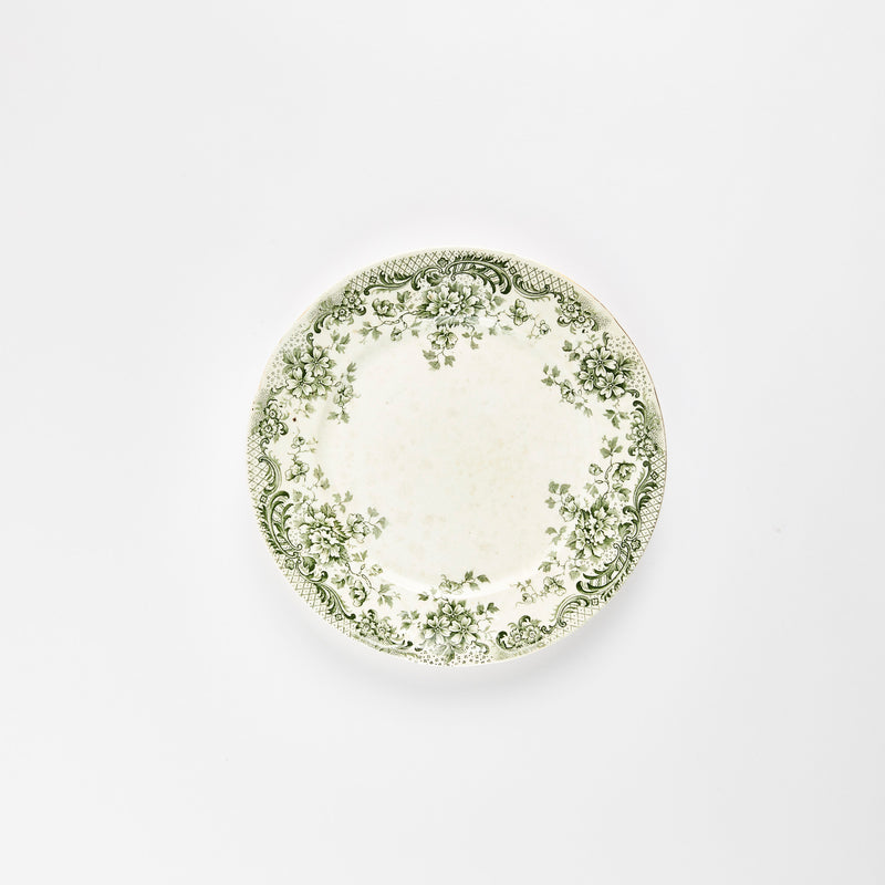 White plate with green leaf and flower decoration.