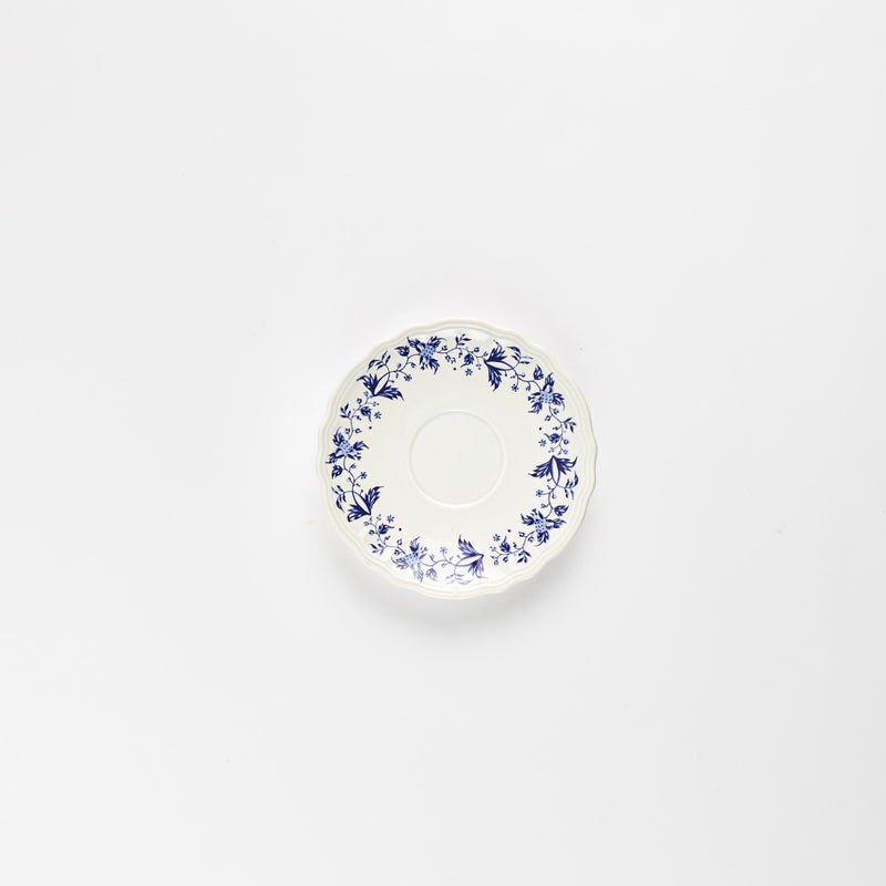 White mini teacup plate with blue flower print.