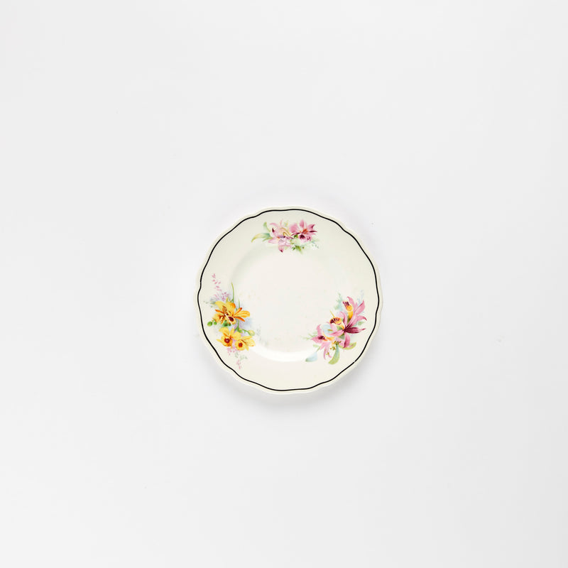 White teacup plate with multicolour flower detail.