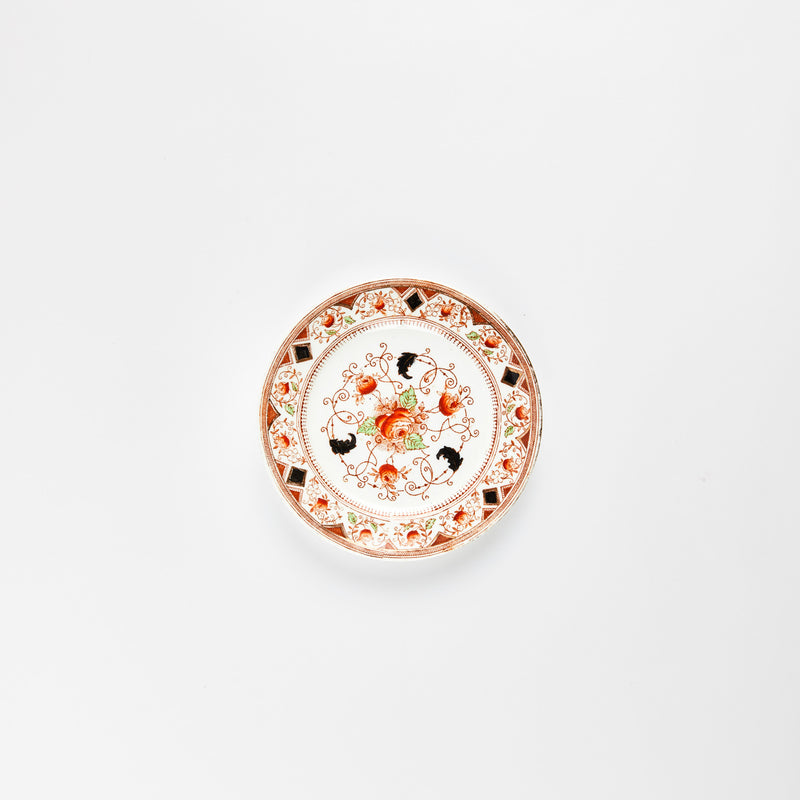 White plate with red, black and green floral detail design.