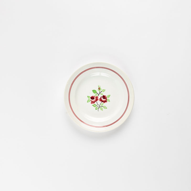 White plate with red flower.