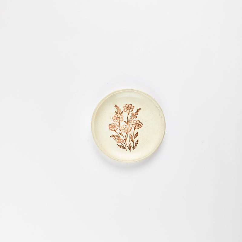 Beige plate with brown embossed flower detail.