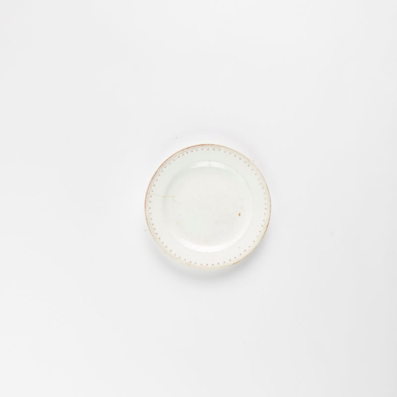 White plate with light brown dots and rim.