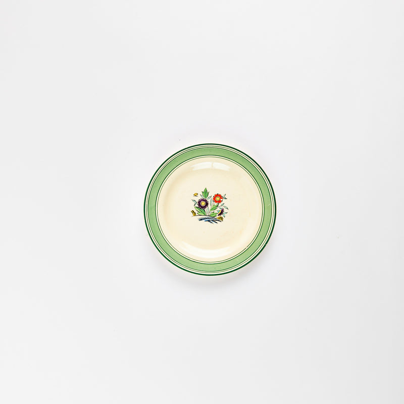 Cream and green plate with flower design in the center.