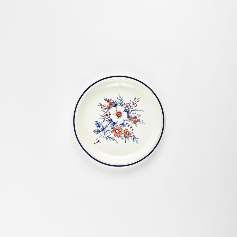 White ceramic plate with blue floral detail in center.