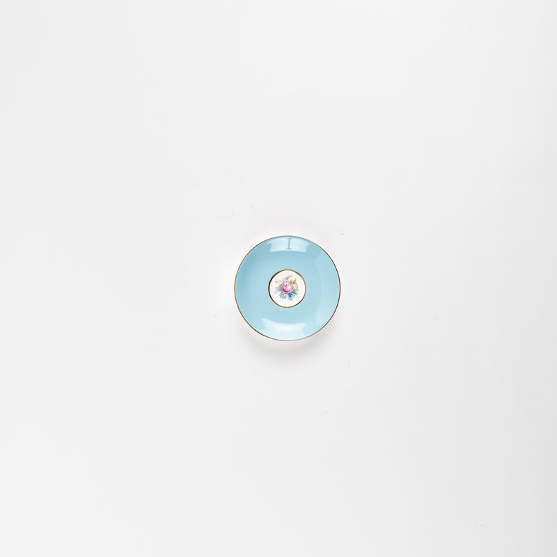 Baby blue teacup plate with flower in center.