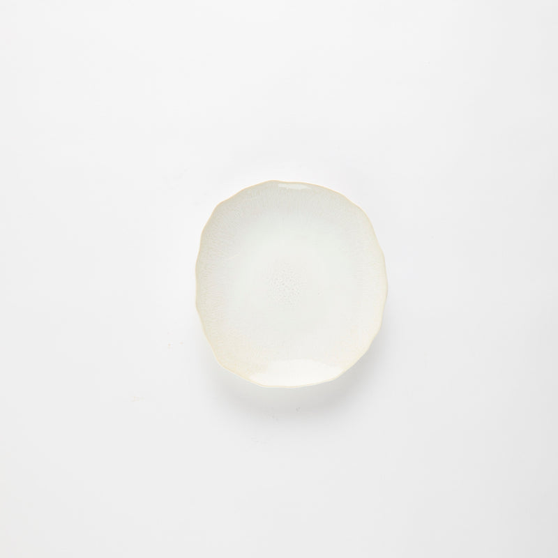 Cream glazed plate with wavy edges.