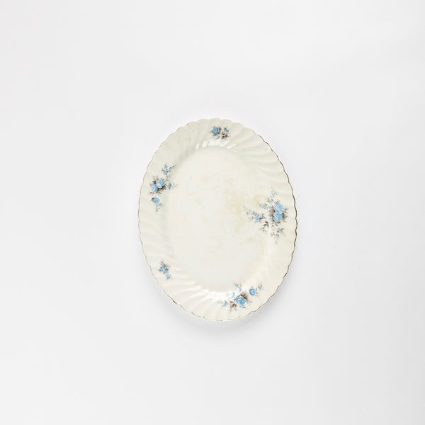 White platter with light blue floral detail and silver scalloped edge.