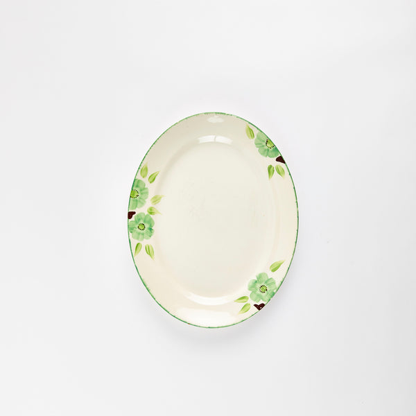 Cream platter with green flowers on rim.