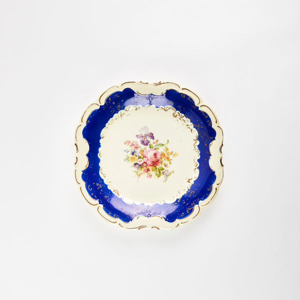 Vintage cream platter with floral centre, gold detailing and blue rim.