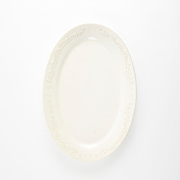 Cream oval ceramic platter with embossed decorative rim.