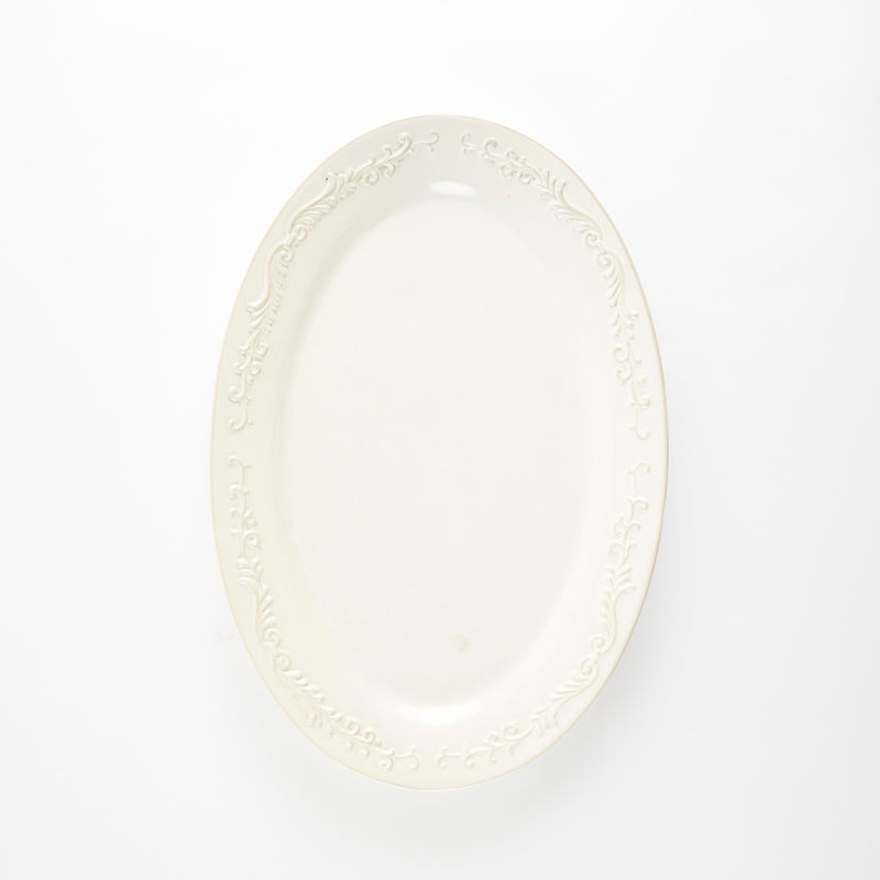 Cream oval ceramic platter with embossed decorative rim.