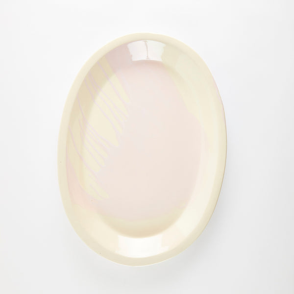 Cream oval ceramic platter with pink splashed glaze.