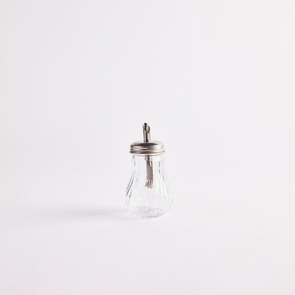 Clear glass shaker with silver top.