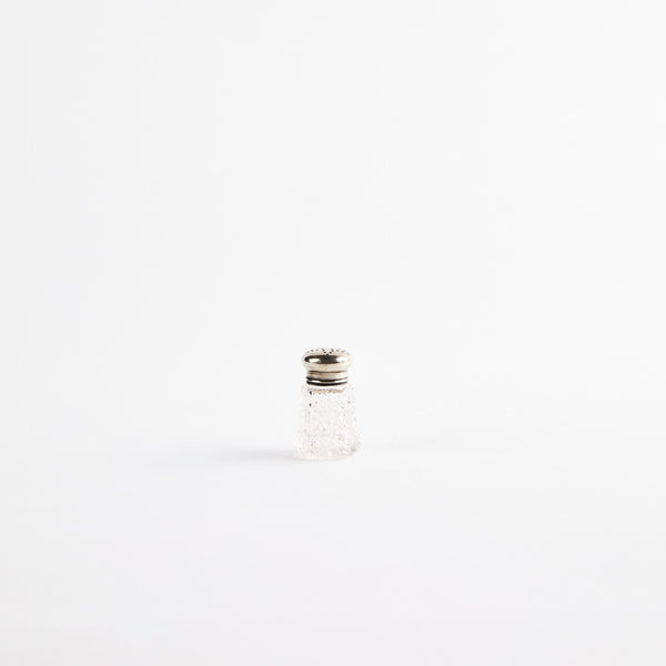 Clear glass shaker with metal top.