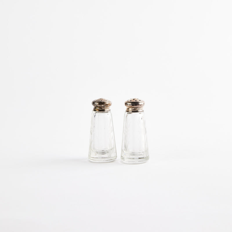 Clear glass shakers with metal tops.