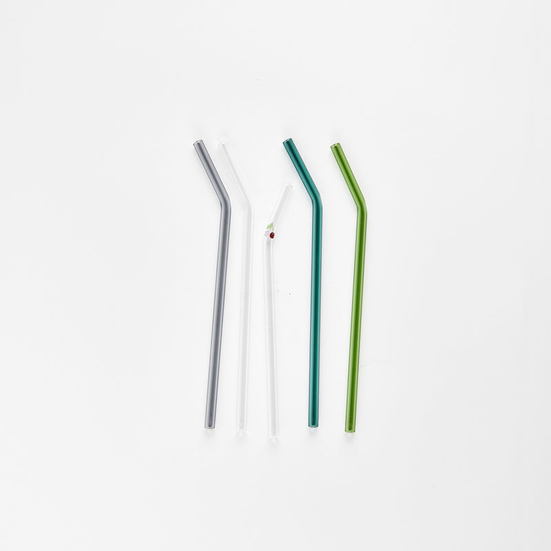 One grey, two clear and two green glass straws.