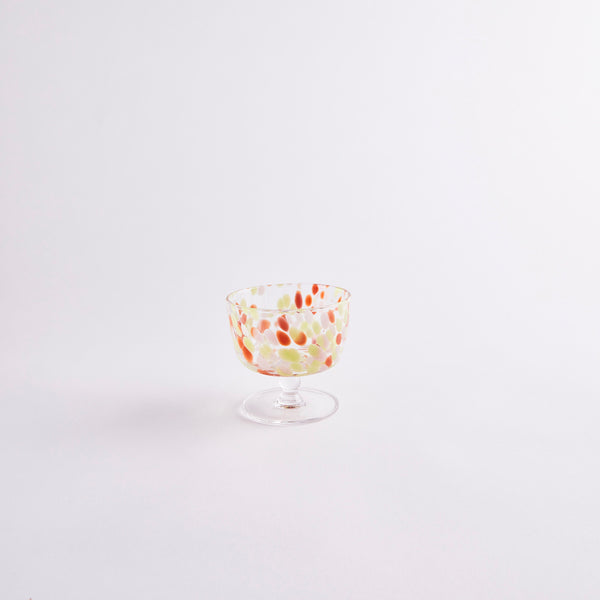 Clear glass coupe with pink, red and green spots.