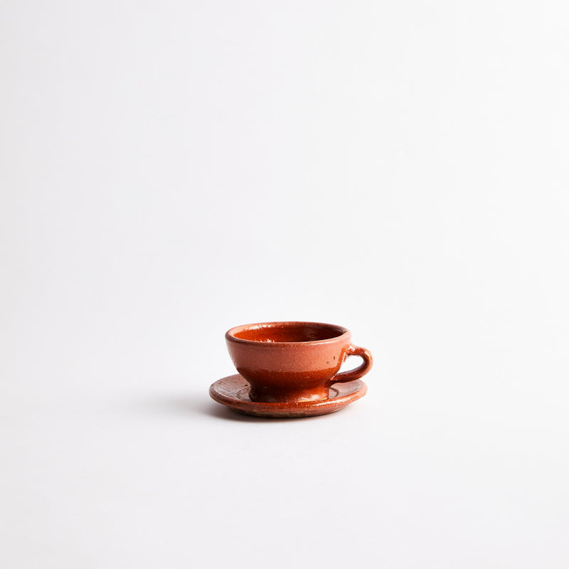 Terracotta teacup with saucer.