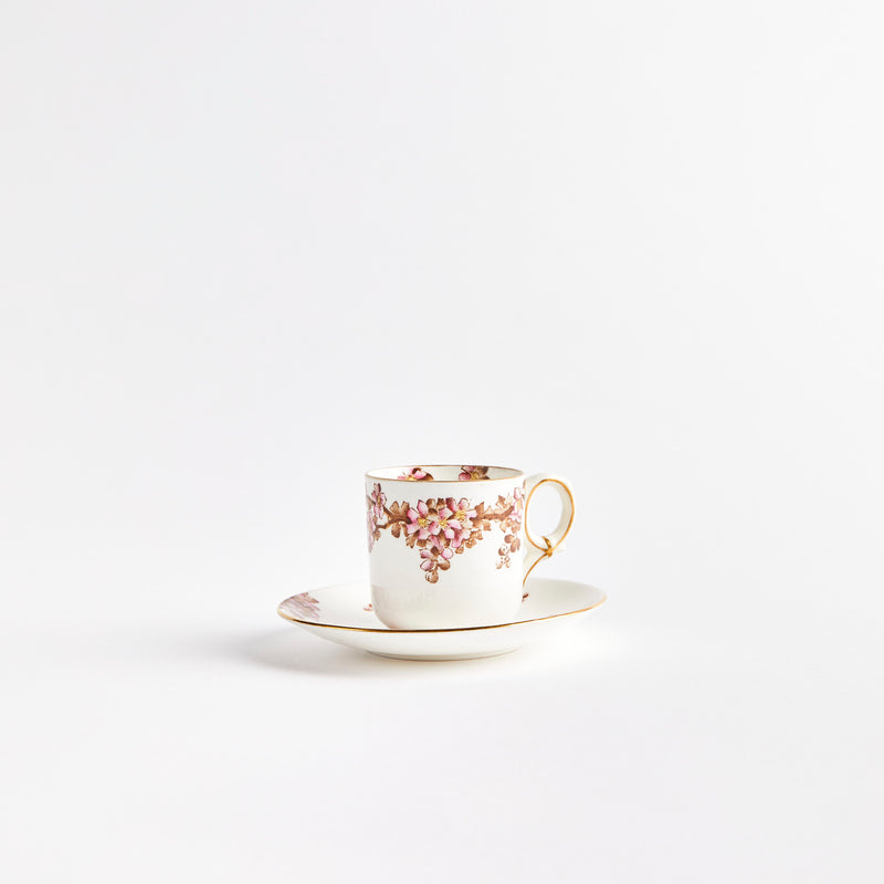 White teacup and saucer with pink flowers and gold detailing.